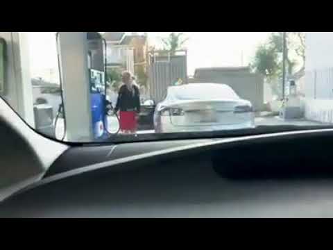 Woman trying to put gas in her electric